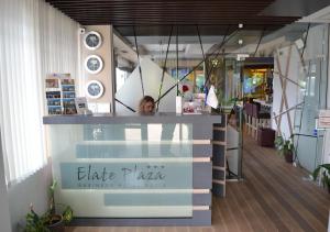 a woman is standing behind a counter in a store at Elate Plaza Hotel in Sofia