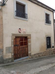 ein Gebäude mit einer Holztür auf einer Straße in der Unterkunft Casa Rural El Callejo in Hinojosa de Duero