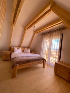 ein Schlafzimmer mit einem Bett und einem großen Fenster in der Unterkunft HILL VIEW Chalets in Žabljak