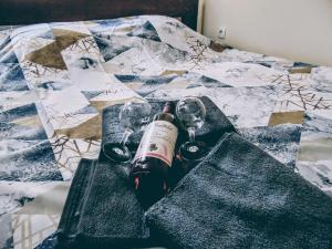 Una botella de vino encima de la cama en Sunny Days apartman Kopaonik, en Kopaonik