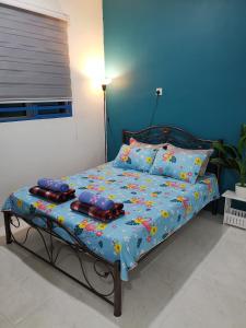 a bed with pillows on it in a room at LYNN HOMESTAY SERI ISKANDAR in Seri Iskandar