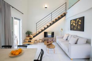 a living room with a white couch and a staircase at Grappolo Lefkada Villas - Athiri, 5 min from wonderful Ai Giannis beach & Lefkada town in Apolpaina