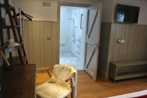 a bathroom with a shower and a chair in a room at The Crown Pub, Dining & Rooms in Henlow