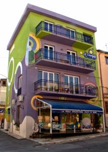 un edificio púrpura y verde con balcones. en La Conchiglia Case Vacanze, en Balestrate