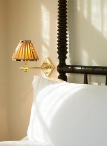 
a person holding a lamp over a bed at The Ludlow Hotel in New York
