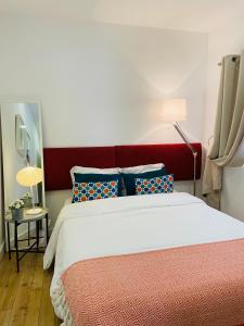 Schlafzimmer mit einem großen Bett mit einem roten Kopfteil in der Unterkunft Enjoy Casa dos Corvos Apartment in Lissabon