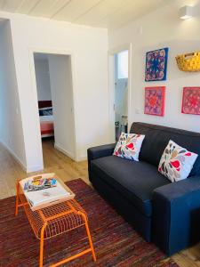 ein Wohnzimmer mit einem schwarzen Sofa und einem Couchtisch in der Unterkunft Enjoy Casa dos Corvos Apartment in Lissabon