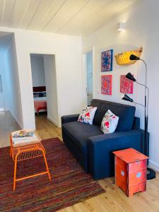 ein Wohnzimmer mit einem blauen Sofa und einem Tisch in der Unterkunft Enjoy Casa dos Corvos Apartment in Lissabon