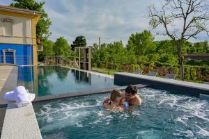 un garçon et une fille sont dans une piscine dans l'établissement Borgo Stazione Bike Inn, à Valeggio sul Mincio