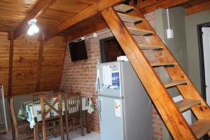 a kitchen with a ladder next to a refrigerator at Cabañas :Doña María Nuñez in Gualeguaychú