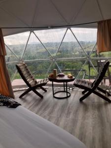 a room with two chairs and a table in front of a window at Barichara Glamping in Barichara