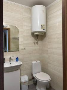 a bathroom with a white toilet and a sink at Солнечная двушка в порту in Kherson