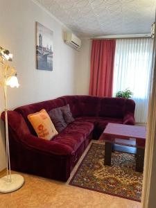 a living room with a red couch and a table at Солнечная двушка в порту in Kherson