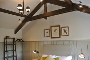 Henlow的住宿－皇冠酒館、餐廳及住宿賓館，客房设有一张床和带横梁的天花板