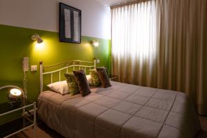 um quarto com uma cama com paredes verdes e uma janela em Hôtel le Cantou 354 em Loubressac