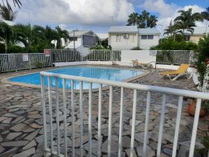 una piscina con una valla blanca alrededor en STUDIO FACE MARINA, en Saint-François