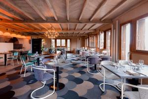 a restaurant with tables and chairs and a chandelier at Hôtel le Cantou 354 in Loubressac