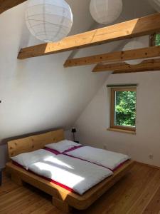 1 dormitorio con 1 cama de madera y 2 luces en Domeček uprostřed přírody en Krásná Lípa