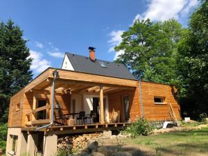 Cette cabane en rondins dispose d'une terrasse couverte et d'un toit. dans l'établissement Domeček uprostřed přírody, à Krásná Lípa
