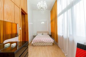 - une chambre avec un lit et un lustre dans l'établissement Town Center Rustaveli ApartHotel, à Tbilissi