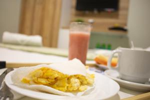 ein Teller Frühstücksspeisen und ein Glas Saft in der Unterkunft Pureza Hotel in Timon