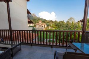 a balcony with tables and a view of a mountain at Famissi Eden Hotel in Kalabaka