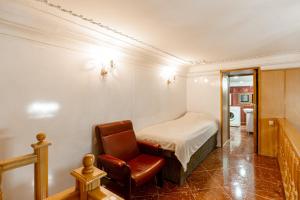 1 dormitorio con 1 cama y 1 silla en Rustaveli Downtown ApartHotel, en Tiflis