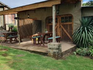 d'une terrasse avec une table, des chaises et une clôture. dans l'établissement Rustique, à Graskop