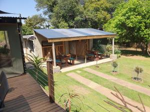 ein Haus mit einem Sonnendach auf einer Terrasse in der Unterkunft Rustique in Graskop