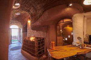 a kitchen with a stone fireplace in a room with a table at CASA PEQUÉN in San Pedro de Atacama