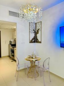 a dining room with a table and chairs and a chandelier at Luxurious Studio Pacific Al Marjan Island - beachfront property in Ras al Khaimah