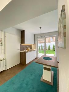 una cucina con armadi bianchi e un tappeto blu di Apartment Dalia a Sarajevo
