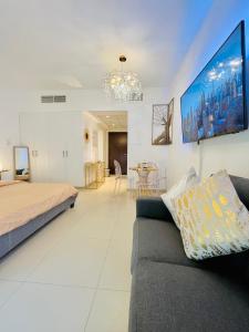 a living room with a couch and a tv at Luxurious Studio Pacific Al Marjan Island - beachfront property in Ras al Khaimah