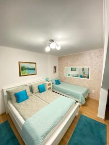 Apartment Dalia في سراييفو: سريرين في غرفة مع وسائد زرقاء