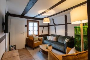 a living room with a couch and a table at Gîtes et chambres d'hôtes Maison Ungerer in Hunspach