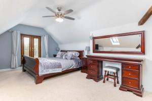 a bedroom with a bed and a dresser with a mirror at The Pigsty - 3 Bedroom Barn Conversion in Coventry