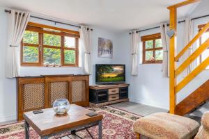 a living room with a television and a staircase at The Pigsty - 3 Bedroom Barn Conversion in Coventry