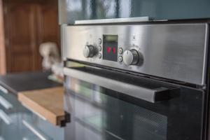 un primer plano de un horno microondas en una cocina en La maison des marronniers, en Bayeux