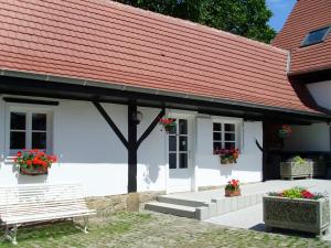 a white building with a red roof and two benches at Gîtes et chambres d'hôtes Maison Ungerer in Hunspach
