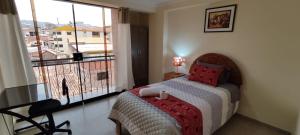 1 dormitorio con cama y ventana grande en INTI SUMAQ WASI, en Cusco