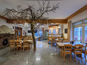 um restaurante com mesas e cadeiras e uma árvore em Hotel Saaletalstuben em Gräfendorf