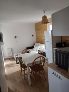 una cucina e un soggiorno con tavolo e sedie di Appartement neuf 4-6 pers. aux pieds des pistes a Génos