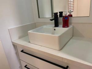 a white bathroom sink with a red extinguisher on it at Max Garden and Pool in Paramaribo