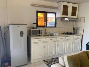 a kitchen with white cabinets and a refrigerator at Max Garden and Pool in Paramaribo