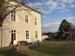 une maison blanche avec un banc dans la cour dans l'établissement Ferienwohnung Beletage, à Varel