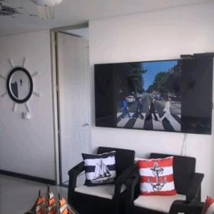 - un salon avec un canapé et une télévision murale dans l'établissement Apartamento Vacacional para Familias en Pozos Colorados Santa Marta, à Santa Marta
