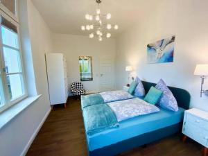 - un lit bleu dans une chambre avec une grande fenêtre dans l'établissement Ferienwohnung Beletage, à Varel