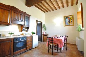 a kitchen with a table and a dining room at Alba su Assisi in Petrignano