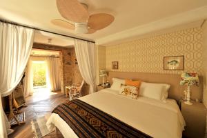 1 dormitorio con 1 cama y ventilador de techo en TW Guaimbê Exclusive Suítes, en Ilhabela