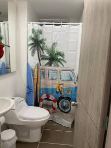 een badkamer met een toilet en een douchegordijn met een busje bij Acogedor Apart piscina, descanso y teletrabajo in Ricaurte